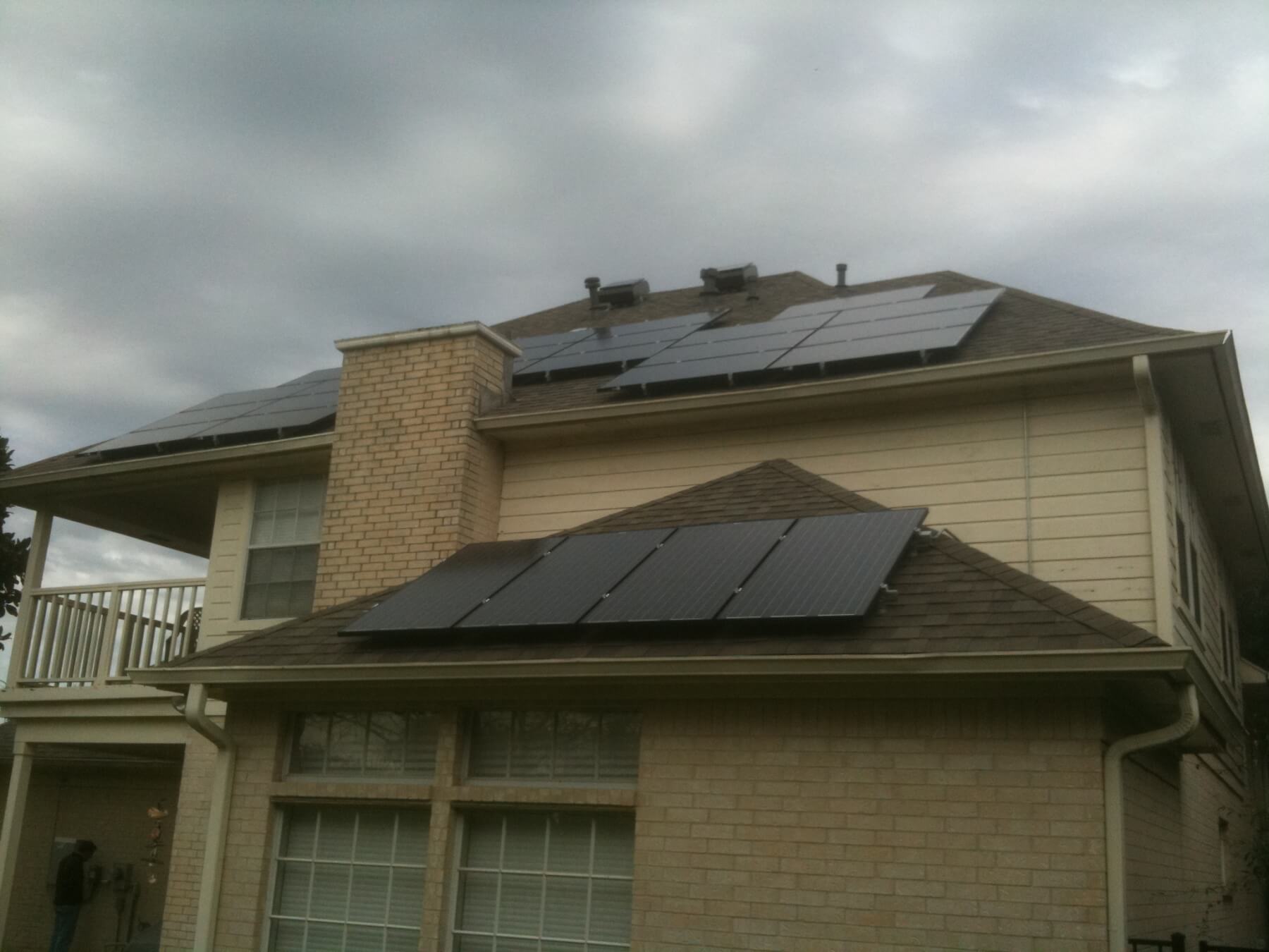House roof with solar panels under cloudy and gloomy sky
