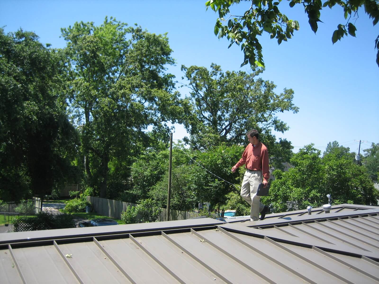 Man checking house roof's condition on a sunny day