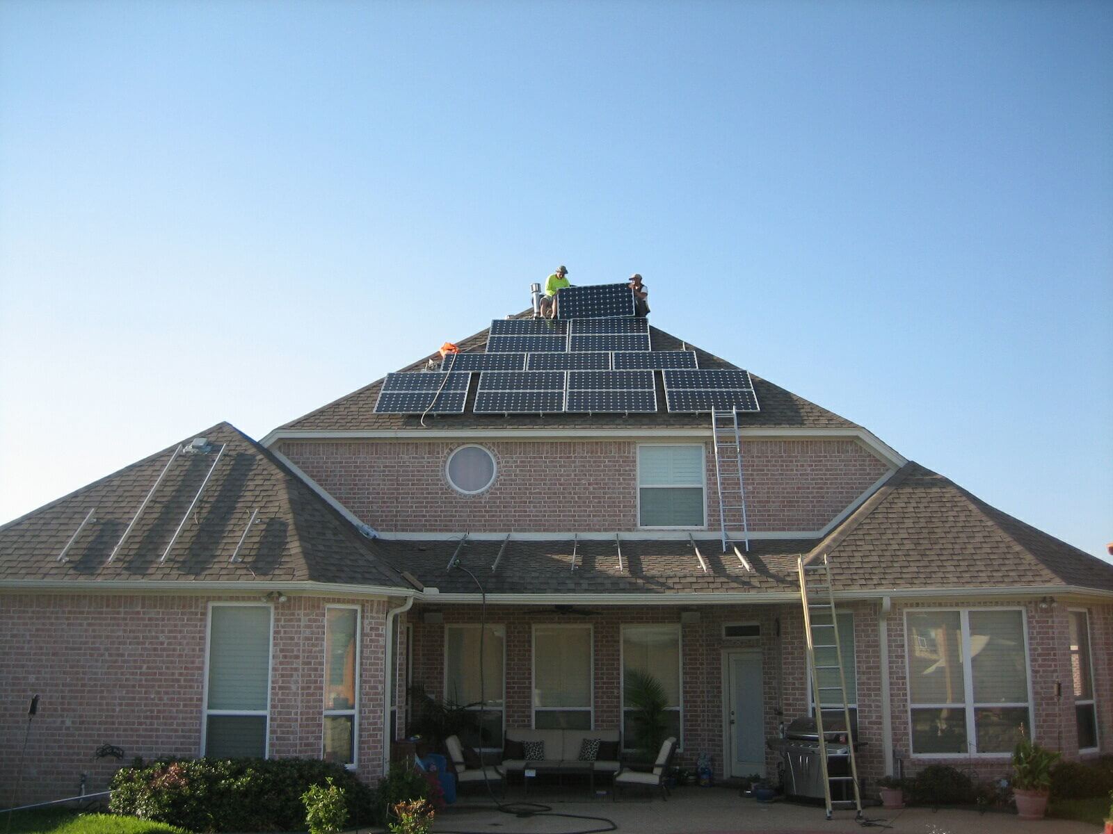 Workers doing maintenance on roof solar panels